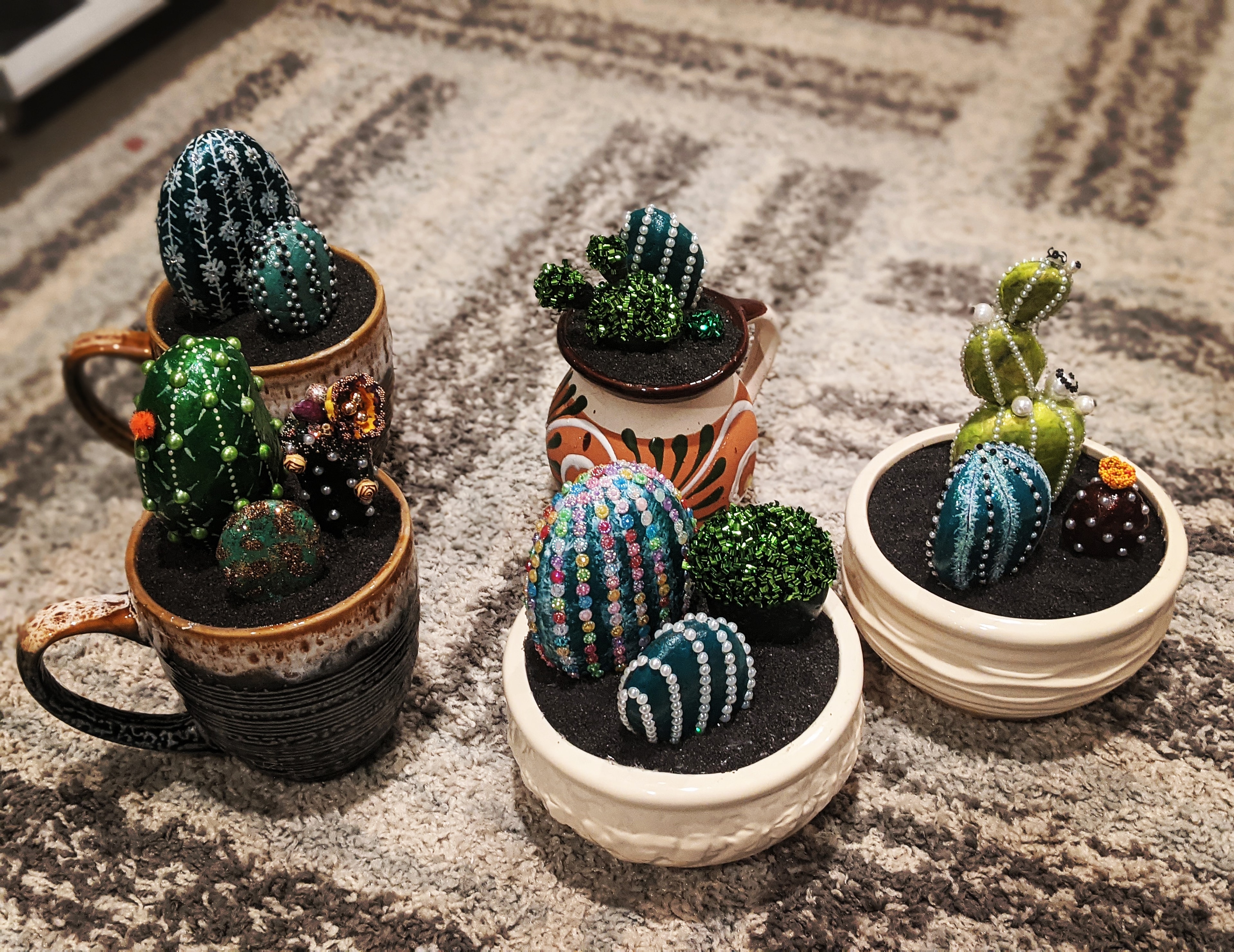 Hand-crafted cactus planter arrangements in ceramic mugs and bowls